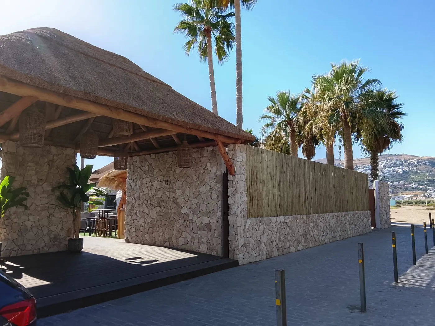 Beach bar de madera con cubierta de paja frente al mar en Marbella