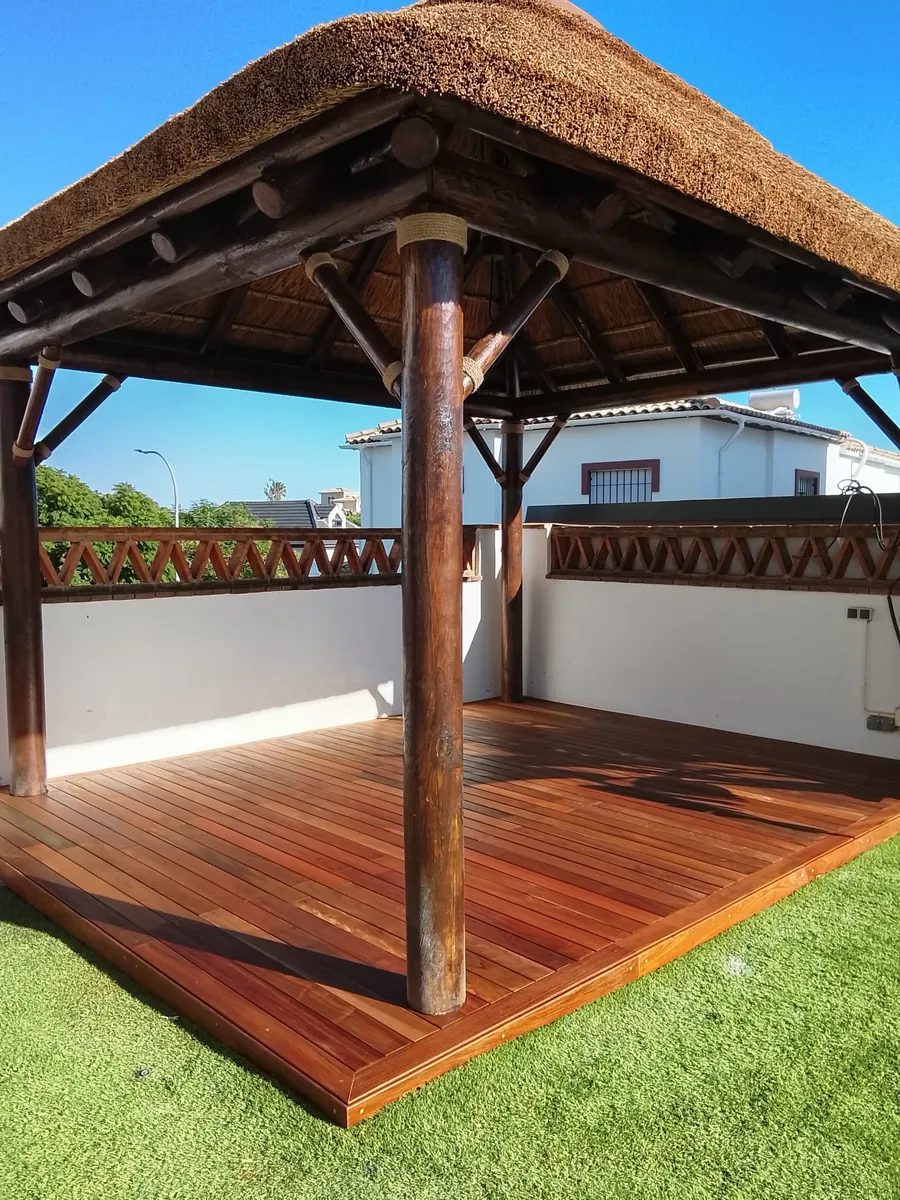 Terraza cubierta con tarima de madera y porche en Marbella